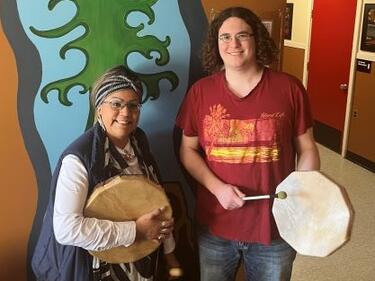 Female elder stands with male student
