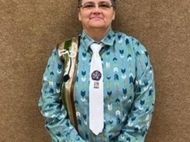 Métis Knowledge Keeper standing in front of brown wall