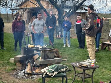 Group of students gathered, listening to an Elder speak