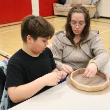 Male grade 5 student and his mother work on making a hand drum