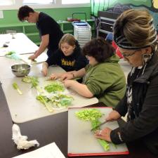 Three students and an ISW chopping vegetables for foods class 