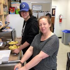 Female teacher poses with male student at the kitchen sink