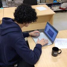 Male student sitting at a laptop completing school work