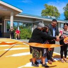 3 adults and 1 students cut the ribbon