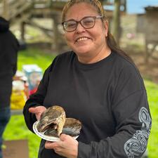 Elder Tina holding fish heads on a plate